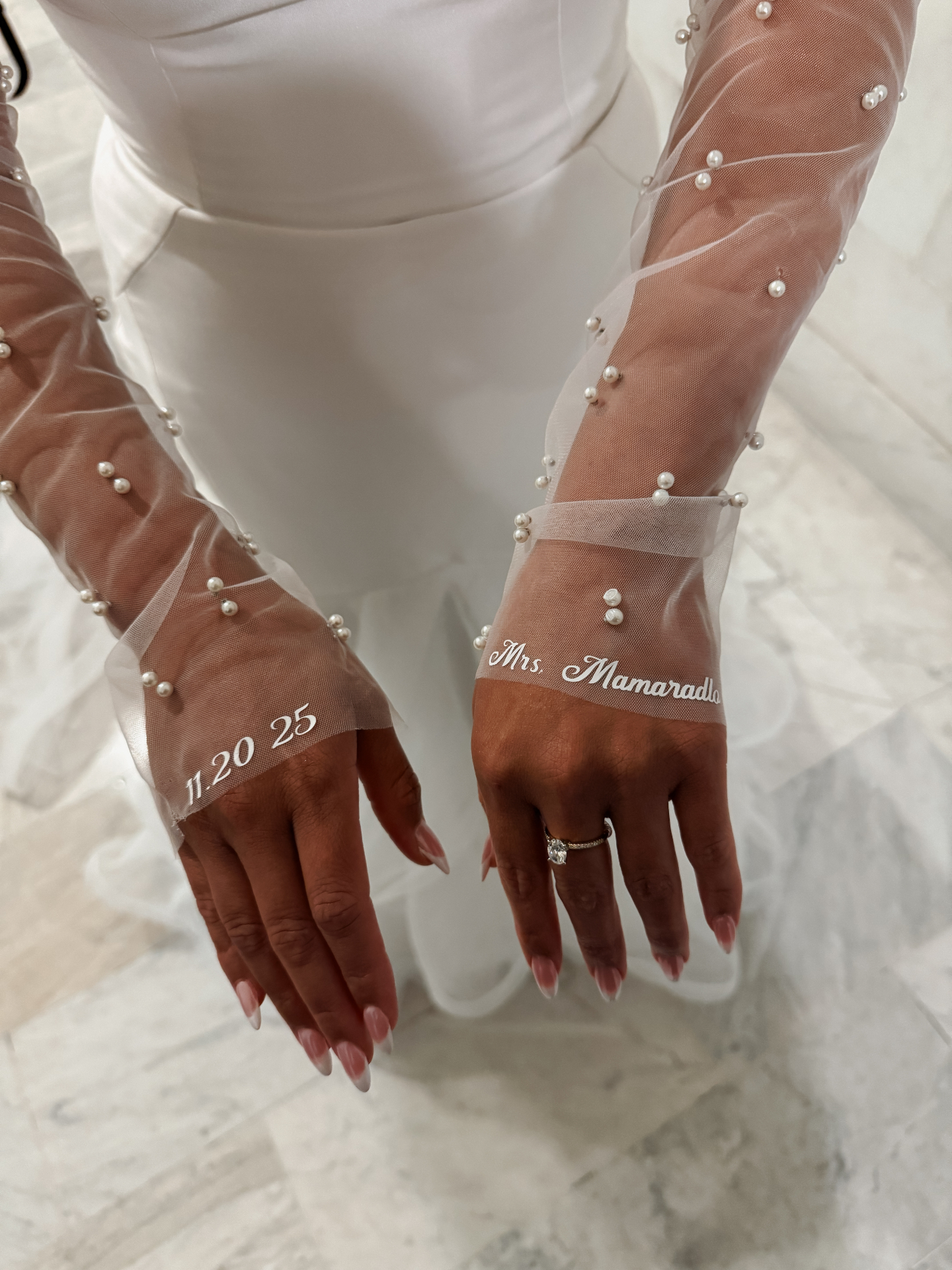 Bride wearing pearl gloves with '11.20.25' and 'Mrs. Mamaradlo' details