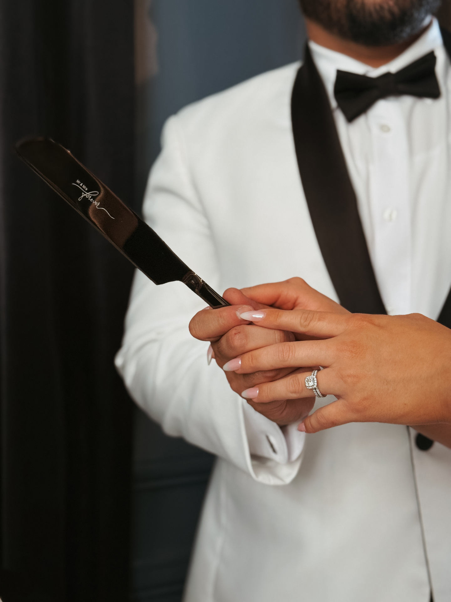 Bride and groom holding 'Mr & Mrs Forever' cake knife